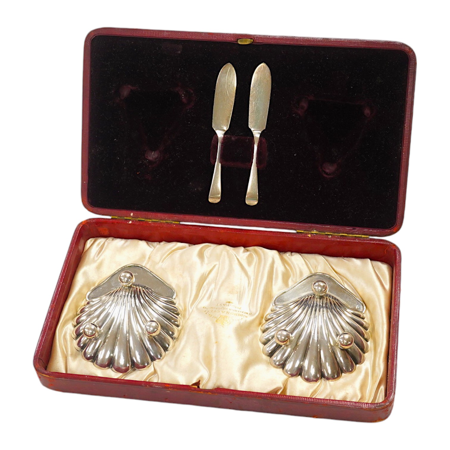 A cased pair of late Victorian silver butter shells with matching butter knives, Horace Woodward & Co Ltd, London, 1897, 95mm. Condition - good